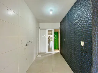 Corredor interno com piso claro e paredes revestidas.