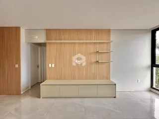 Interior de uma sala com painéis de madeira clara e piso de cerâmica.