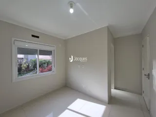 Interior de um corredor com piso de cerâmica e paredes brancas.