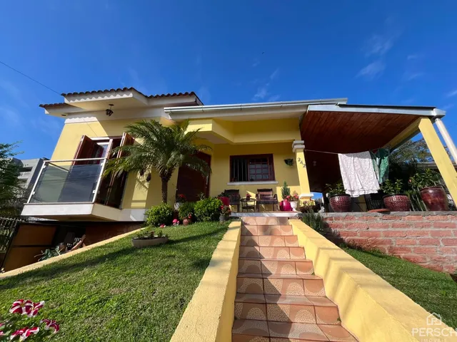Fachada de uma residência em Lajeado, Brasil, com jardim gramado e escadaria.