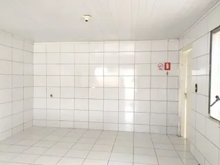 Interior de um corredor com piso de cerâmica branca.