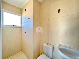 Foto de um banheiro interno com azulejos claros e janela.