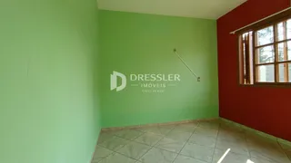 Parede interna de uma sala com piso de cerâmica e janela.