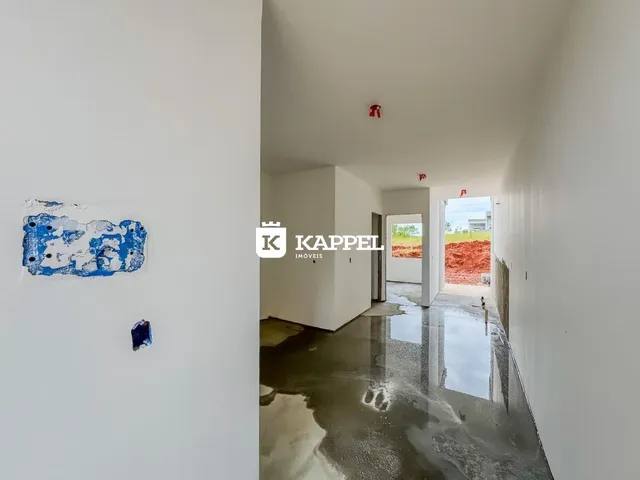 Hall de entrada com piso molhado e paredes brancas em um imóvel em Lajeado.