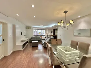 Sala de estar e jantar de um apartamento moderno com piso de madeira.