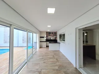 Vista interna de um ambiente com portas de vidro que se abrem para o exterior.