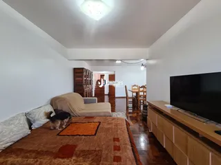 Sala de estar com sofá e cama em um ambiente claro.