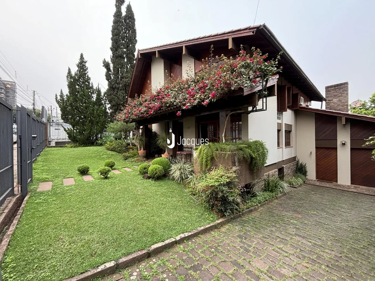 Fachada de uma casa em Lajeado, Brasil com jardim gramado e vegetação.