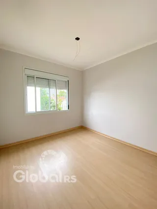Foto de um cômodo interno com piso de madeira clara e janela.