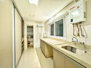 Vista interna de uma cozinha com bancada e janela.