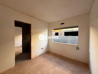 Foto de um cômodo vazio com paredes brancas e piso de concreto exposto.