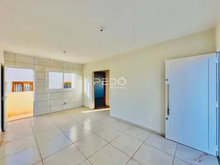 Ambiente interno de uma área com piso de cerâmica e portas de acesso.