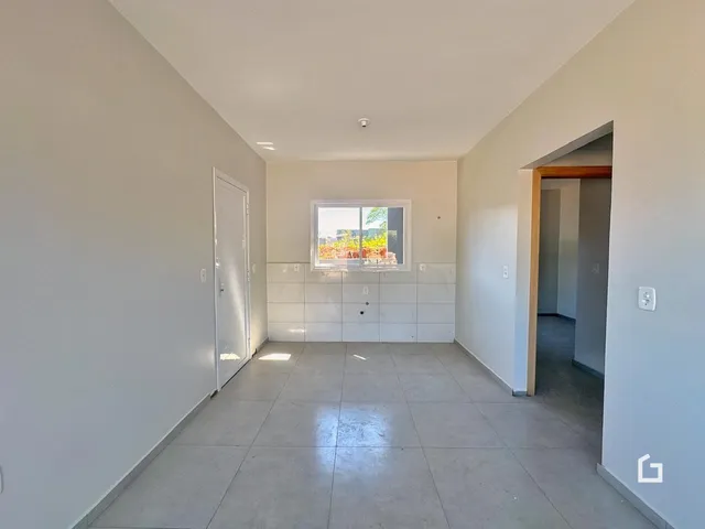 Foto de um corredor interno com paredes brancas e piso de cerâmica.