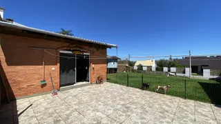 Fachada de casa de tijolos vermelhos com uma área pavimentada à frente.