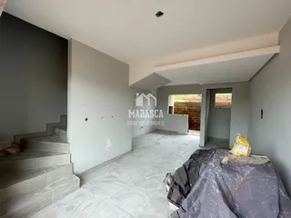 Interior de uma área com paredes de concreto e escadaria em construção.