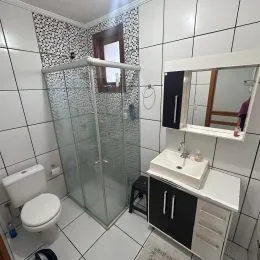 Foto de um banheiro com revestimento de azulejos brancos.