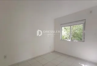 Ambiente interno com paredes brancas e piso de cerâmica.