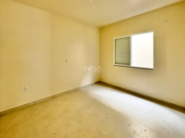 Ambiente interno de uma sala com piso de cerâmica e parede amarelada.