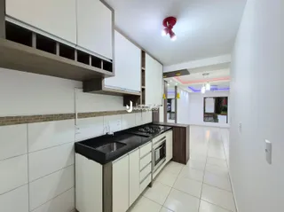 Cozinha moderna com armários brancos e piso claro.