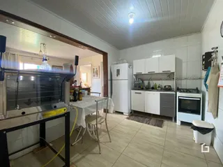 Interior de uma cozinha com armários e mesa de jantar em Lajeado.