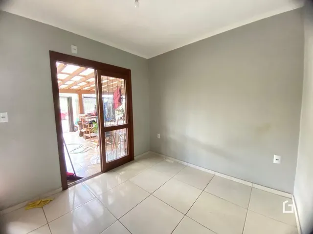 Interior de uma sala com piso de cerâmica e porta de vidro.
