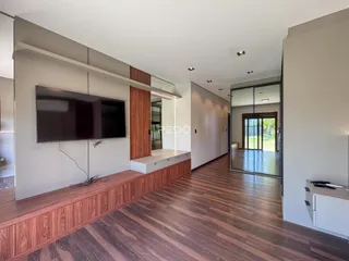 Sala de estar com piso de madeira e móveis modernos.