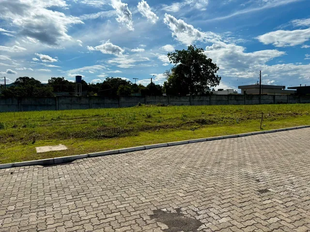 Vista externa de um terreno com grama e cerca de arame.