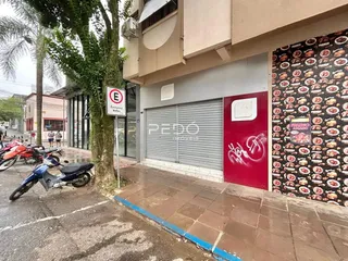 Fachada de um imóvel em Lajeado, Brasil, com uma porta de garagem e publicidade na parede.