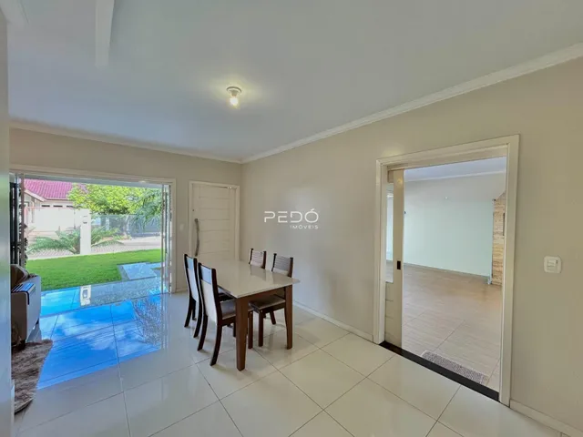 Sala de jantar com piso de cerâmica e porta de vidro abrindo para o exterior.