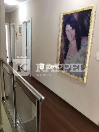 Foto de um corredor interno com piso de madeira e parede clara.
