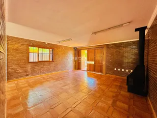 Sala de estar com piso de cerâmica e paredes de tijolo aparente.