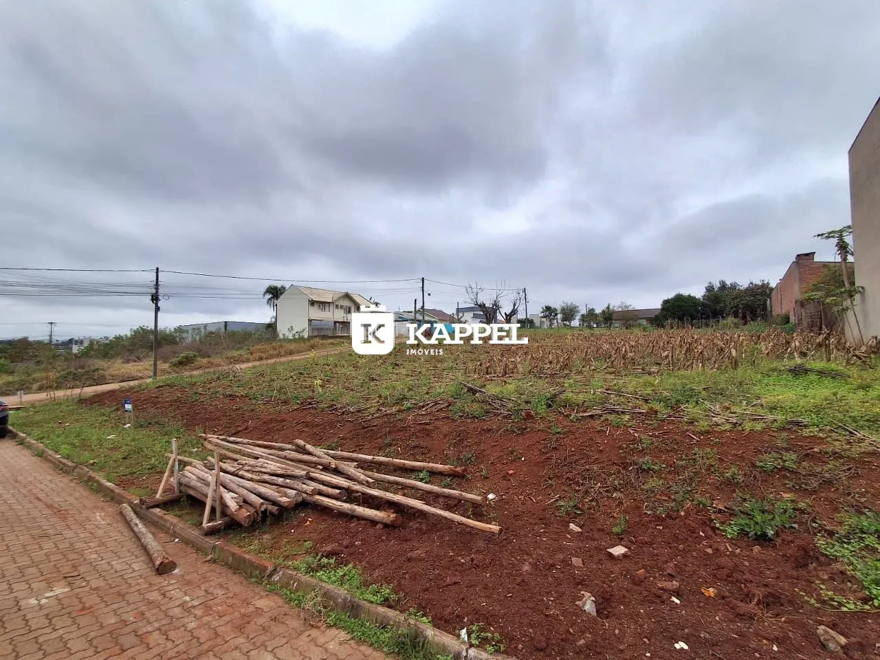 Vista externa de uma propriedade em Lajeado, com terreno baldio em primeiro plano.