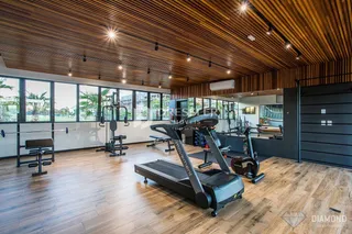 Sala de ginástica com piso de madeira e teto de madeira.