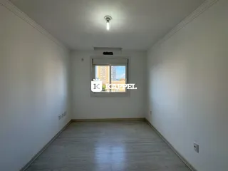 Hall de corredor com paredes brancas e piso de madeira clara.