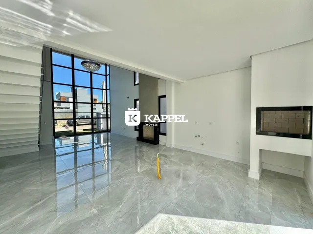 Sala ampla com piso de pedra e porta de vidro que dá para o exterior.