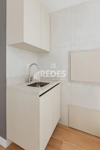 Armários brancos de cozinha com bancada e backsplash em uma propriedade no Brasil.