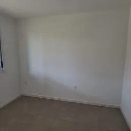 Foto de um cômodo interno com paredes brancas e piso claro.