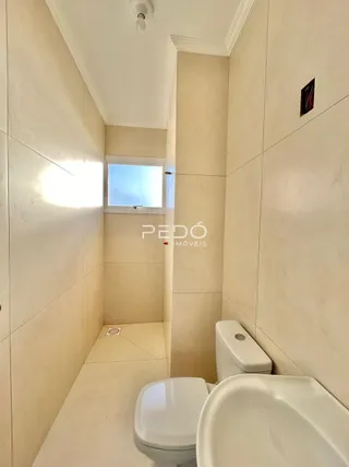 A foto mostra o interior de um banheiro com vaso sanitário e pia.