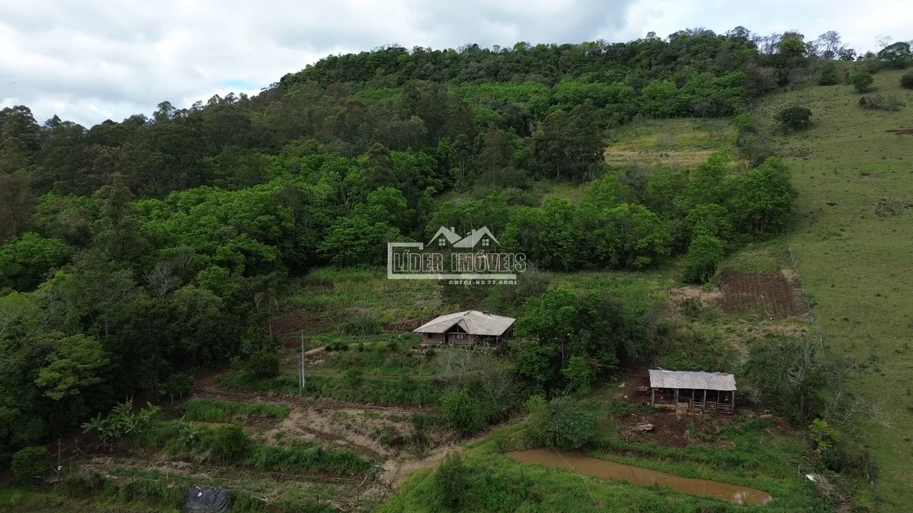 Vista aérea de uma propriedade rural com vegetação densa na serra de Lajeado, Brasil.