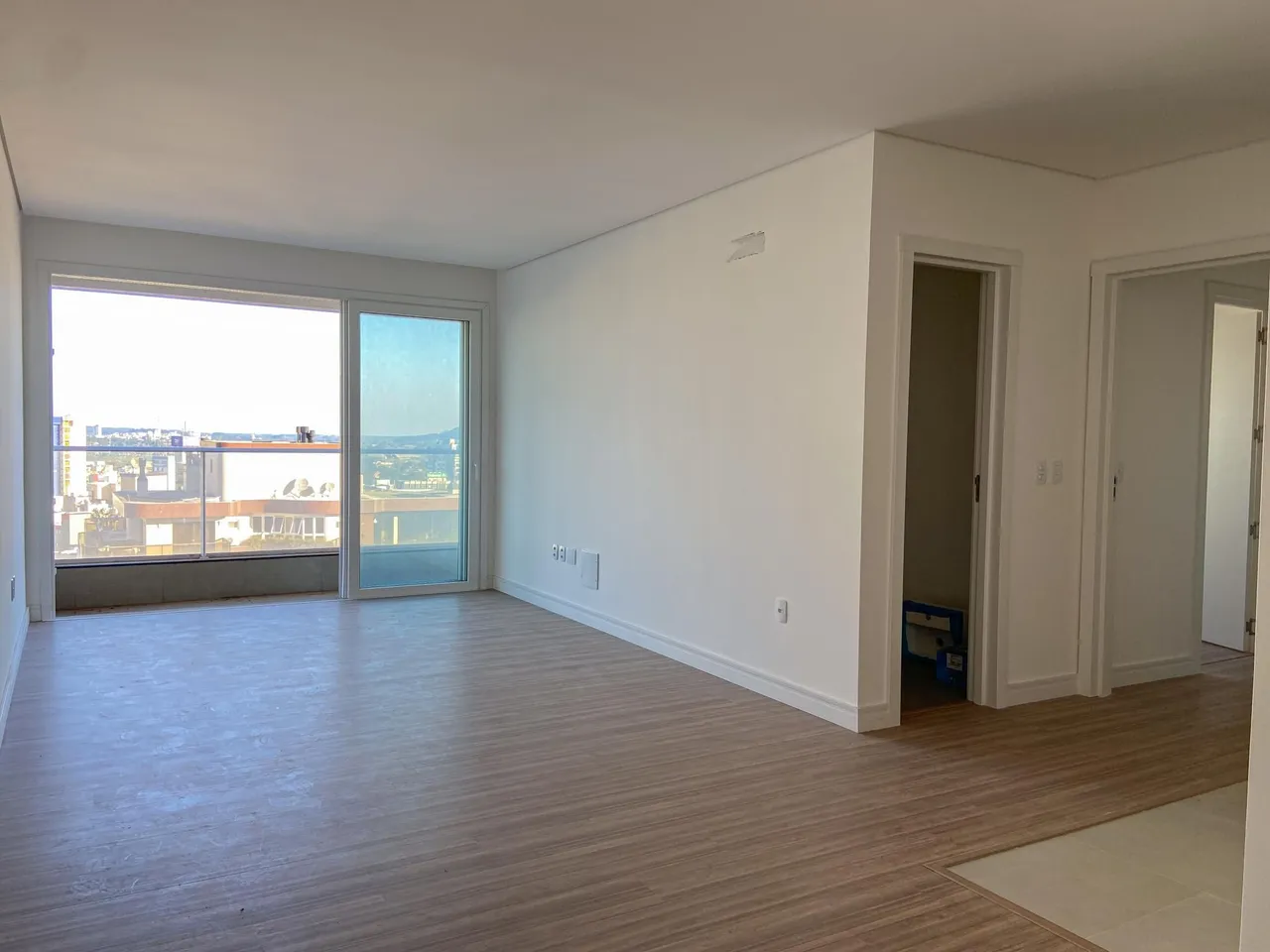 A sala de estar apresenta uma grande janela com vista para a paisagem urbana.