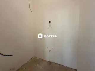 Foto de um canto de cômodo com paredes brancas e piso cru.