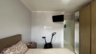 Quarto com cama e televisão montada na parede.