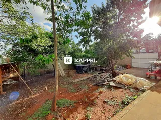Vista externa de um terreno com vegetação e solo de terra.