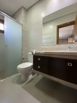 Foto de um banheiro com revestimento cerâmico e louças sanitárias.