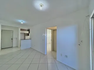 Vista de um corredor interno com piso de cerâmica branca.