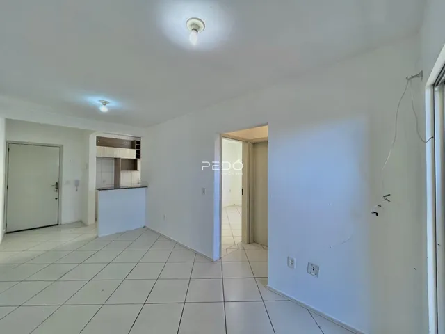 Vista de um corredor interno com piso de cerâmica branca.