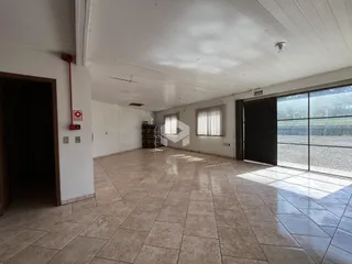 Espaço interno amplo com piso de cerâmica e teto alto.