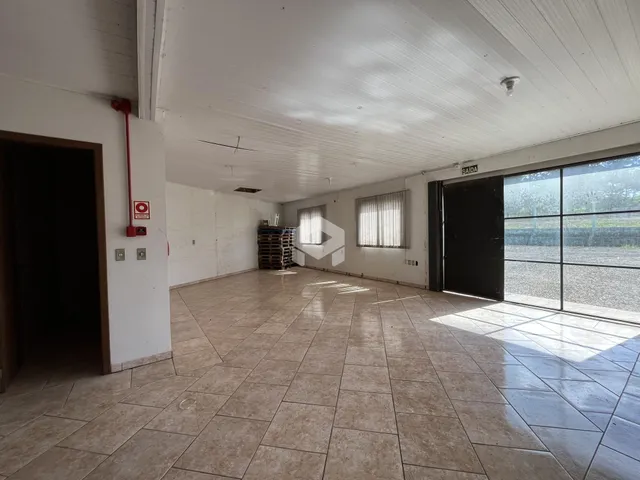 Espaço interno amplo com piso de cerâmica e teto alto.
