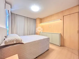Quarto com cama e armário em um apartamento moderno.