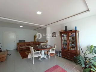 Sala de estar com sofá e mesa de jantar em um apartamento.